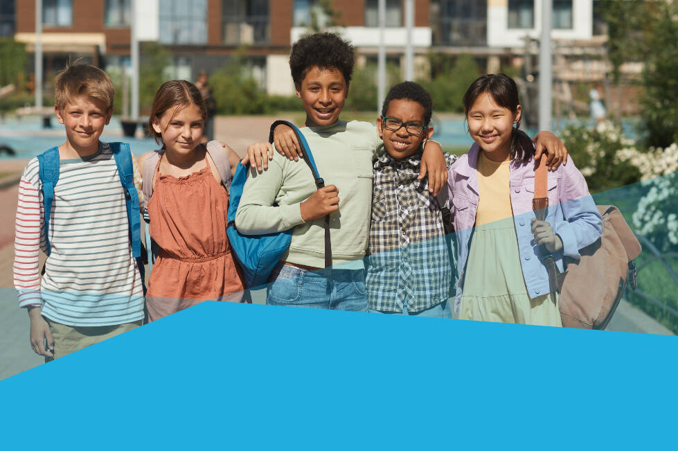 Five children wearing backpacks outside smiling with their arms around each other
